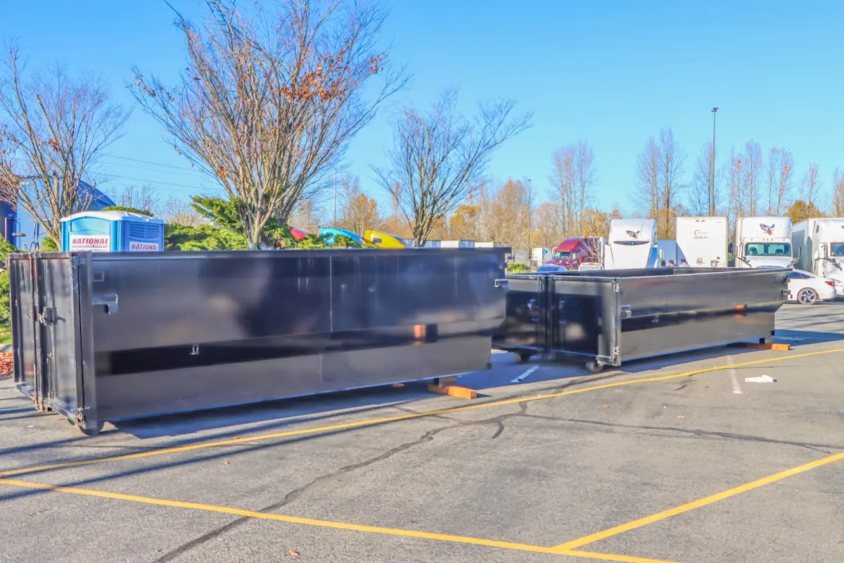 Professional dumpster rental service with roll-off container on residential driveway in Shiprock